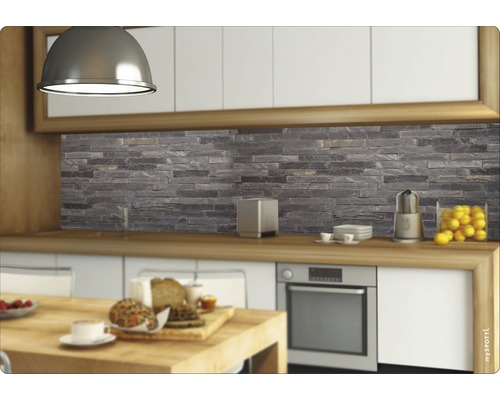 Köksscen med en bakvägg i stenlook bakom arbetsbänken