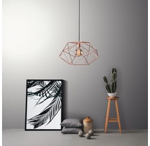 Dekorativ hänglampa med geometrisk design, kompletterad med inredningsdetaljer som fotoram, kuddar och kaktus.