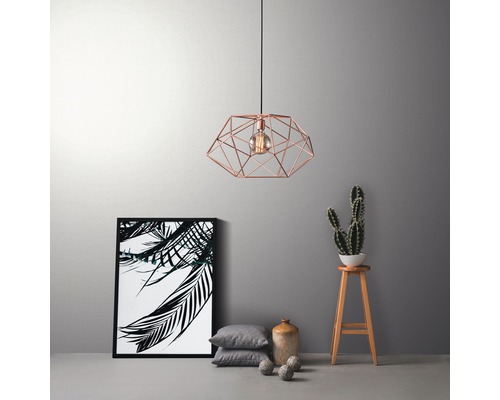 Dekorativ hänglampa med geometrisk design, kompletterad med inredningsdetaljer som fotoram, kuddar och kaktus.