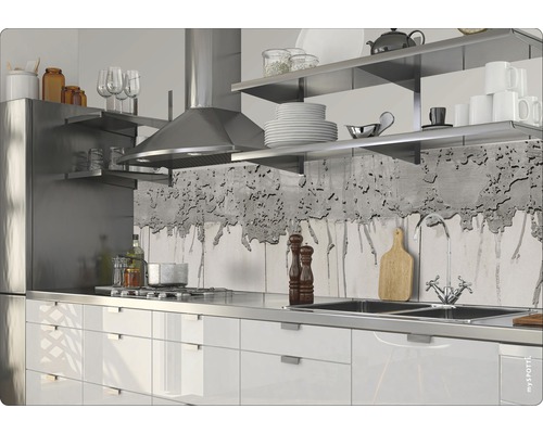 Köksscen med vita skåp, diskho i rostfritt stål, spis och fläkt.