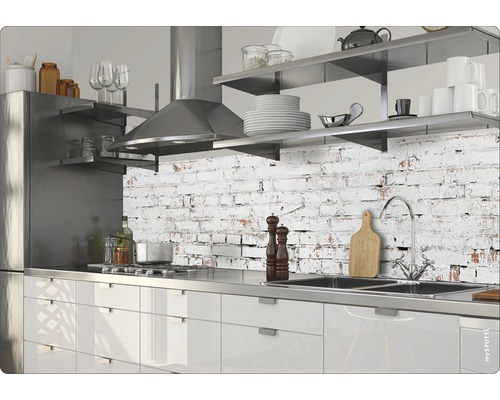 Modernt kök med rostfria vitvaror och bänkskiva framför en vägg med tegelmönster