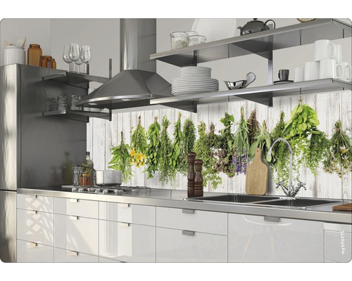 Köksscen med vita skåp, diskho i rostfritt stål och örtmotiv på bakväggen