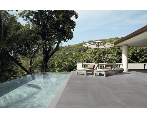 Uteplats med grått kakelgolv, pool och solstolar