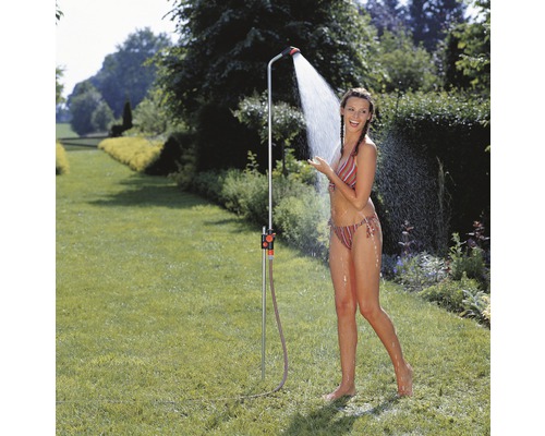 Trädgårdsdusch med en kvinna i trädgården