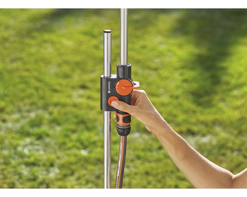 Gardena vattenfördelare med hand på regulatorn för trädgårdsbevattning