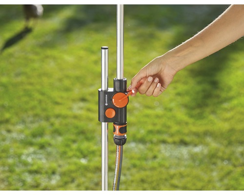 En hand manövrerar en vattenfördelare på en trädgårdskran.