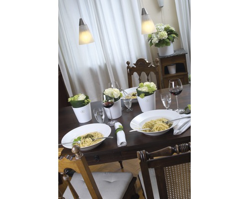 Dukat matbord med pasta, drycker, blommor och lampor