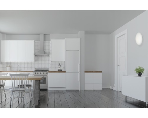 Ljust kök med köksmöbler, matbord och vägglampa