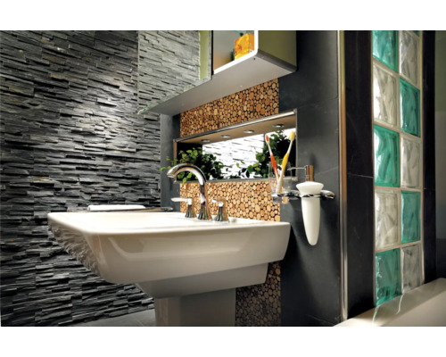 Badrum med handfat, blandare, spegel, väggbeklädnad av sten och glasbetong