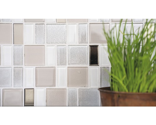 Detaljbild av en vägg med glasmosaikplattor och dekoration