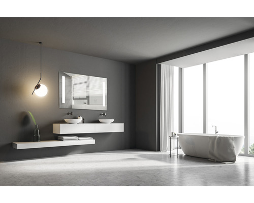 Badrum med badkar, tvättställ, spegel och stort fönster för en ljus atmosfär