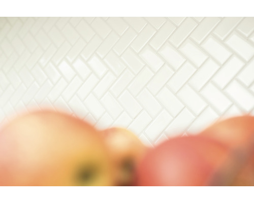 Vägg med vita kakelplattor i fiskbensmönster