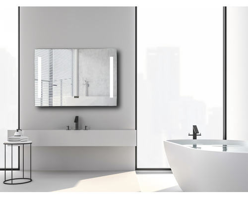 Badrum med belyst spegelskåp, tvättställ och badkar