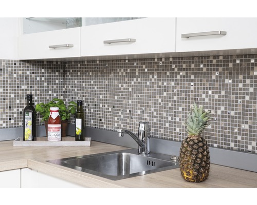 Ljust kök med diskho, mosaikplattor och köksredskap