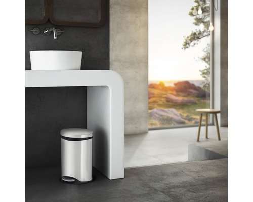 Modernt badrum med handfat, konsol och pedalhink i rostfritt stål