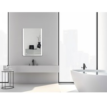 Badrum med handfat, spegel, badkar och minimalistisk design