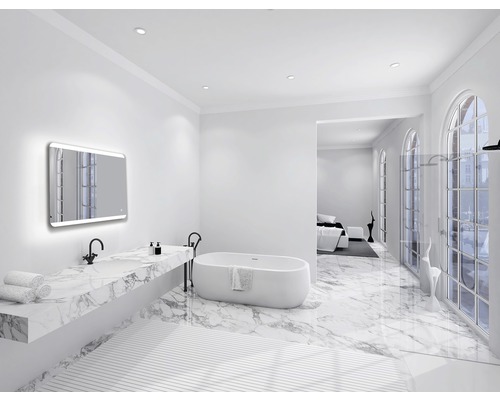 Ljust badrum med badkar, tvättställ med marmorskiva och upplyst spegel