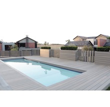 Swimmingpool med trädäck och trästaket framför bostadshus