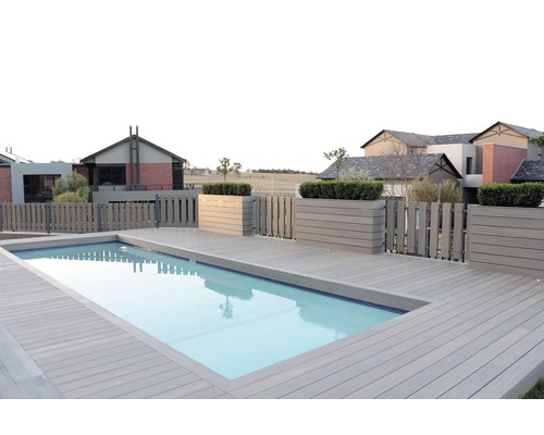 Swimmingpool med trädäck och trästaket framför bostadshus