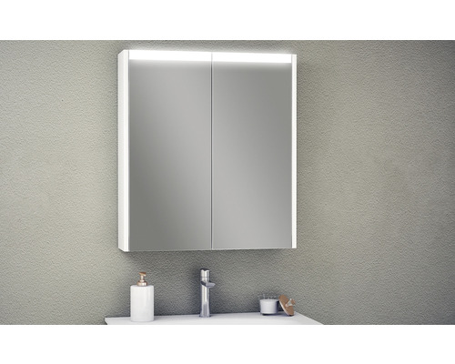 Belyst spegelskåp med två dörrar ovanför ett handfat i badrummet