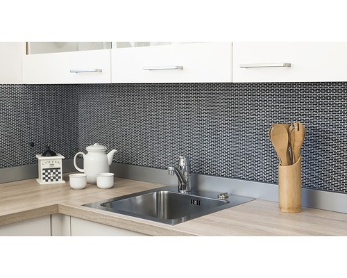 Köksscen med diskho, kran, kaffekvarn, porslin och köksredskap mot en mosaikbakgrund