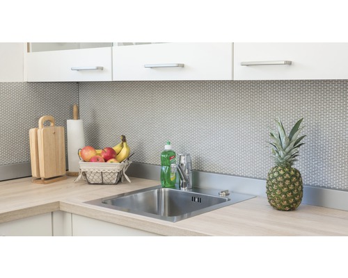 Köksscen med diskho, kran, skärbrädor, hushållspapper, fruktkorg och ananas