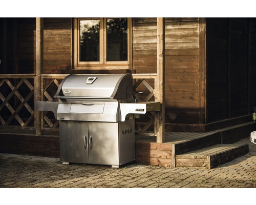 Napoleon grill med underskåp framför ett trähus