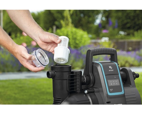 Person sätter in filter i trädgårdspumpen.