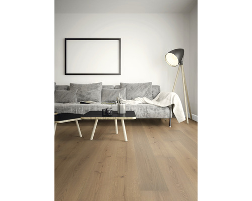 Ljust vardagsrum med trägolv, soffa, bord och golvlampa