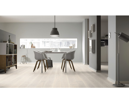 Ljust vardagsrum med matbord, stolar och hyllor på trägolv