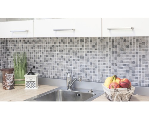 Köksscen med mosaikplattor, diskho och dekorativa element.