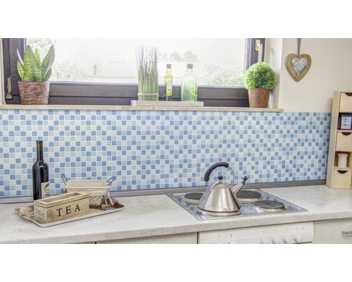 Köksscen med blå mosaikbakgrund, tebox, vinflaska och spishäll