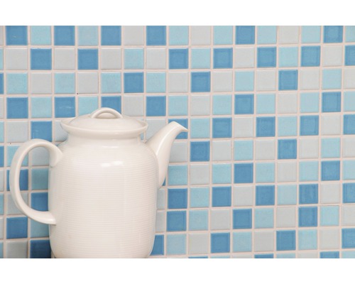 Tekanna av keramik mot en bakgrund av mosaikplattor