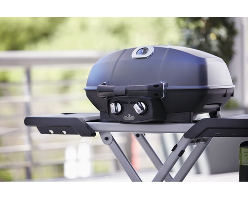 Bärbar gasolgrill på ett bord med nedfällbara sidobord.
