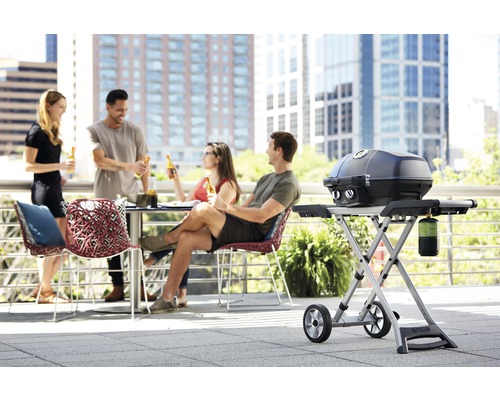 Scen med personer som sitter vid ett bord på en terrass och använder en grill från Napoleon.
