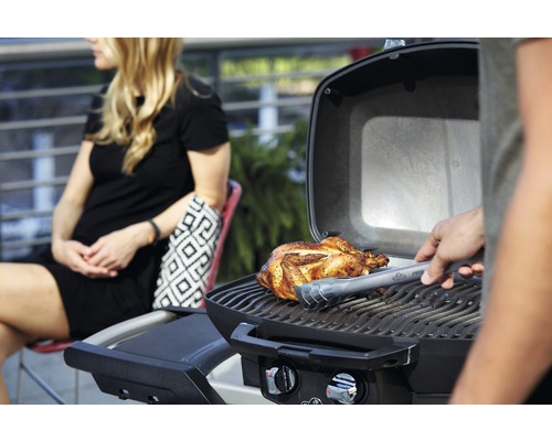 Grill med grillad kyckling och person med grilltång