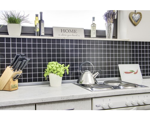 Köksscen med kakel, spishäll, vattenkokare och diverse köksredskap