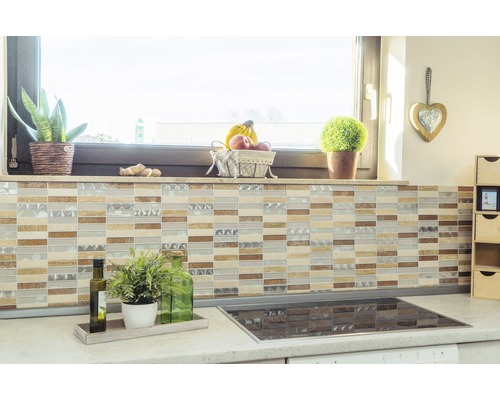 Köksscen med mosaikplattor på väggen, bänkskiva med växter och spishäll