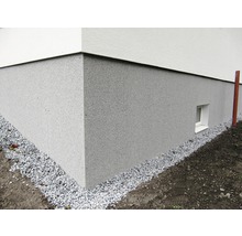 Exteriör av ett hus med sockelputs och grusremsa
