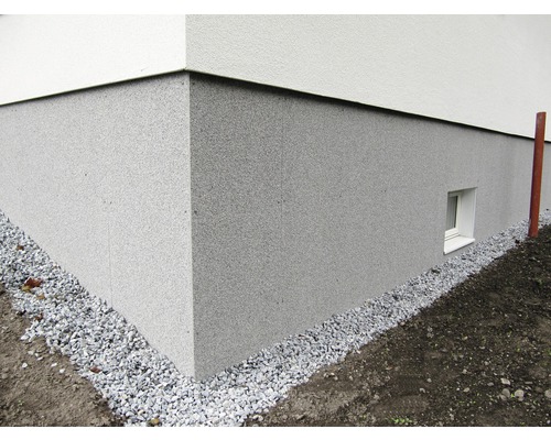 Exteriör av ett hus med sockelputs och grusremsa