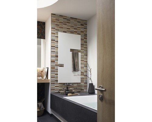 Badrum med badkar, spegel, kakel och badrumsartiklar för en ljus och organiserad atmosfär.