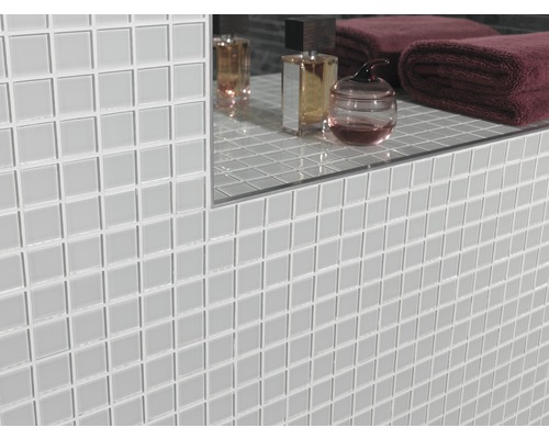 Vägg med ljusa mosaikplattor i badrum