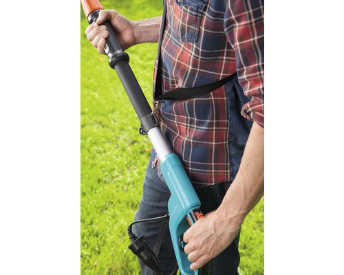 Man använder en elektrisk häcksax i trädgården.