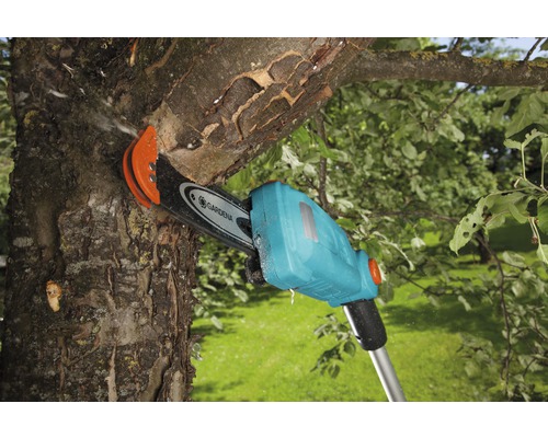 Gardena batteridriven stångsåg sågar av en gren på ett träd.