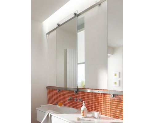 Badrum med skjutbar spegel, handfat och orange mosaikplattor