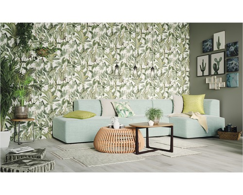 Vardagsrum med soffa, bord och botanisk tapet