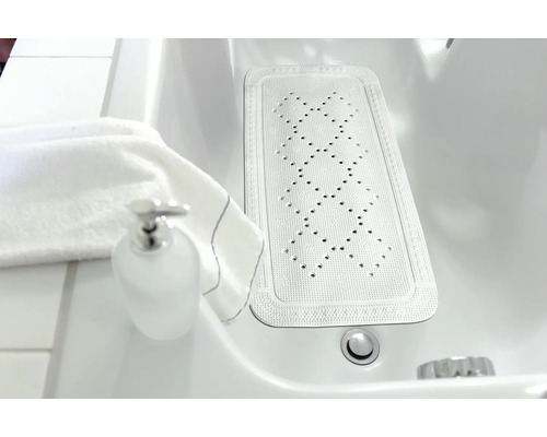 Badkar med badrumsmatta, handduk och tvålpump