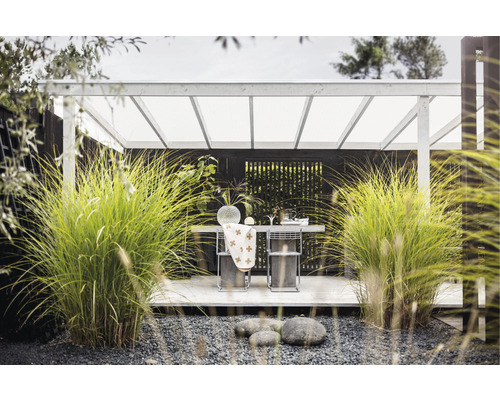 Övertäckt sittgrupp i trädgården med bord och stolar