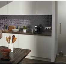 Modernt kök med mosaik, bänkskiva, köksredskap och kaffebryggare.