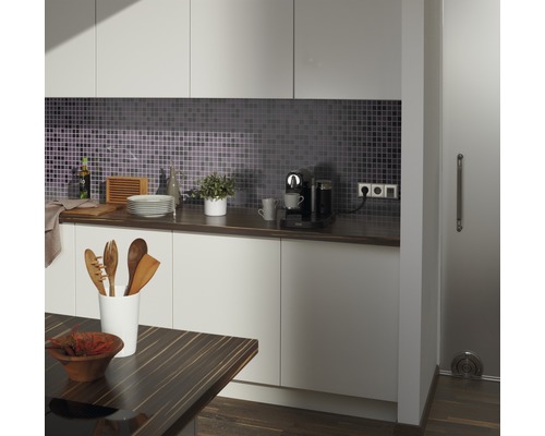 Modernt kök med mosaik, bänkskiva, köksredskap och kaffebryggare.